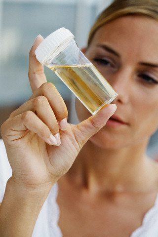 Woman Examining Vial of Urine